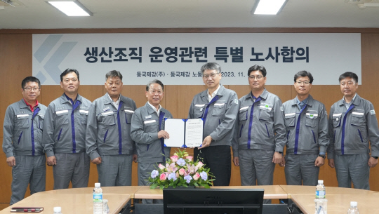 6일 동국제강 인천공장에서 열린 '생산조직 운영 관련 특별 노사합의' 행사에서 최삼영(가운데에서 오른쪽) 동국제강 대표이사 부사장과 박상규(가운데에서 왼쪽) 동국제강 노조위원장이 합의서를 들고 기념사진을 찍고 있다. 동국홀딩스 제공